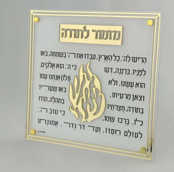 מעמד אקריליק עם מזמור לתודה בזהב ולוגו הלהבה, ושני מחזיקי נרות